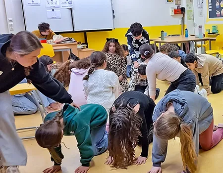 Kinder führen unter Anleitungen Übungen zur Rückengesundheit durch