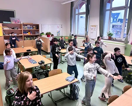 Kinder tanzen in der Klasse vor dem Board